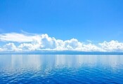 Small blue sky with clouds and ocean